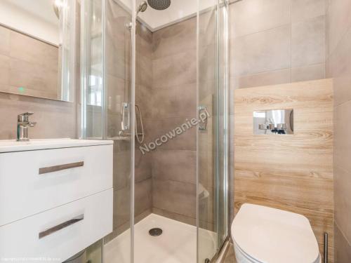 a bathroom with a shower and a toilet and a sink at Apartament LAWENDOWY in Sopot