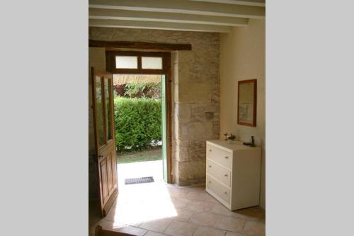 a hallway with a door and a dresser in a room at Petite maison au bord du canal, 8' Zoo de Beauval, PMR in Noyers-sur-Cher
