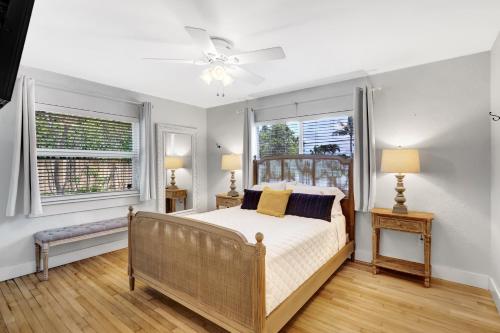 a bedroom with a bed and two windows at Cozy and Charming in SoSo in West Palm Beach