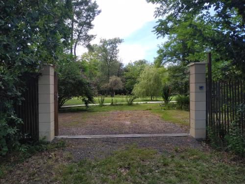 an open gate in a field with a fence at Les roulottes Vesta in Léognan