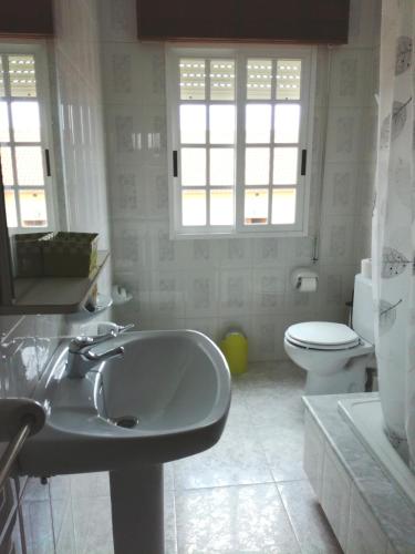 a white bathroom with a sink and a toilet at CASA CENTRICA EN O GROVE in O Grove