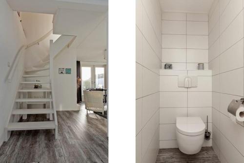 La salle de bains est pourvue de toilettes et d'un escalier. dans l'établissement Vakantiewoning Zwinstraat Zoutelande, à Zoutelande