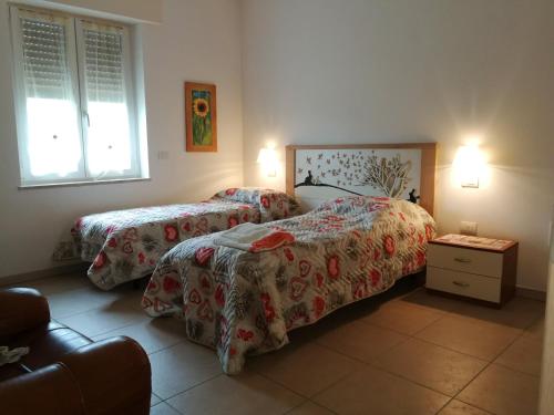 a bedroom with two beds and a table and two lamps at Al Pozzo in Negrar