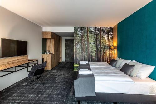 ホイニツェにあるOTTON-Charzykowy Bed&Restaurantの大型ベッド1台、薄型テレビが備わるホテルルームです。