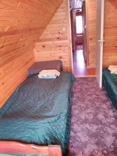 a bedroom with two beds in a wooden cabin at Vahtra Vacation House in Käsmu