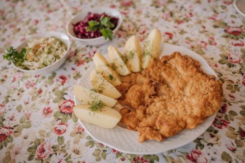 a plate of chicken and apple slices on a table at Zajazd Blue in Stare Miasto