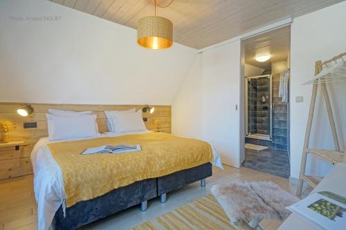 B&B Maison Ruthier في وايمس: غرفة نوم مع سرير وممشى في الدش