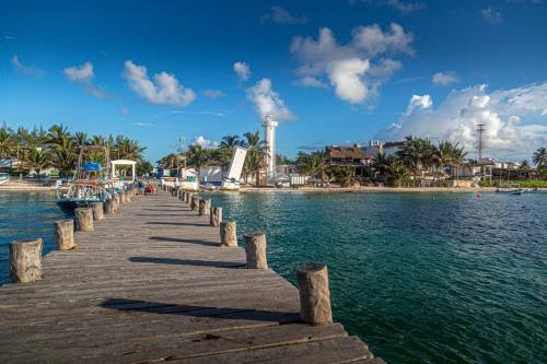 a wooden pier over the water on a beach at Casa Marene in Puerto Morelos