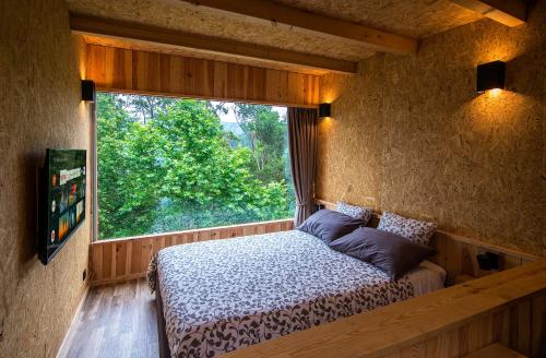 a bedroom with a bed and a large window at Welcome to Gerês-Green view in Vieira do Minho