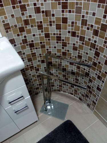a bathroom with a sink and a tiled wall at penzion Za lávkami in Dačice