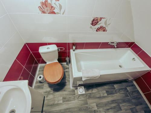 a bathroom with a tub and a toilet and a sink at Ubytování u Kapličky in Kunějov