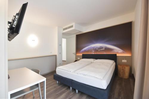 a bedroom with a bed with a large painting on the wall at Primavera ApartmentSuites in Riva del Garda