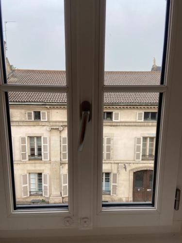 a window with a view of a building at Le Duplex St Nicolas in Beaune