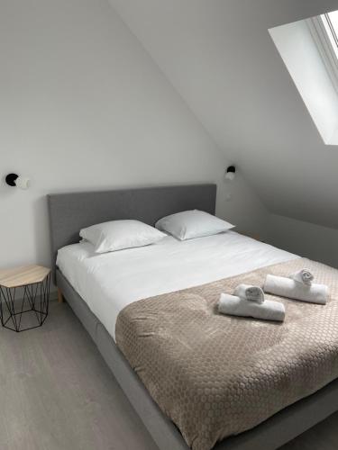 een slaapkamer met een bed met twee handdoeken erop bij Le Duplex St Nicolas in Beaune