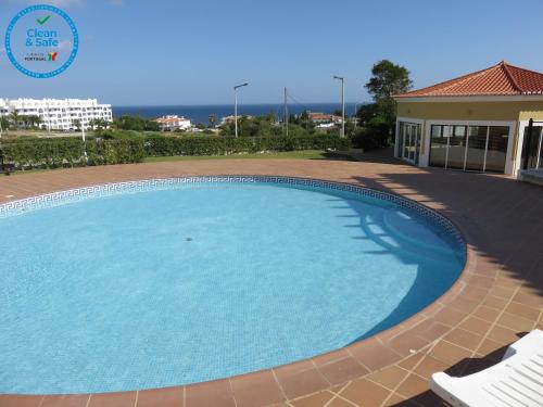 una gran piscina de agua azul en un patio en Apartamento T1 com vista mar perto da Praia N.ª Sra. da Rocha, en Porches