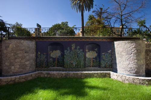a wall with a mural of palm trees on it at Grand Hotel La Favorita in Sorrento