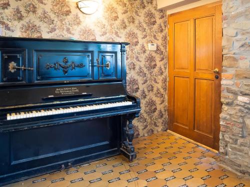 a blue piano in a room with a door at Holiday home with sauna and swimming pool in Verviers