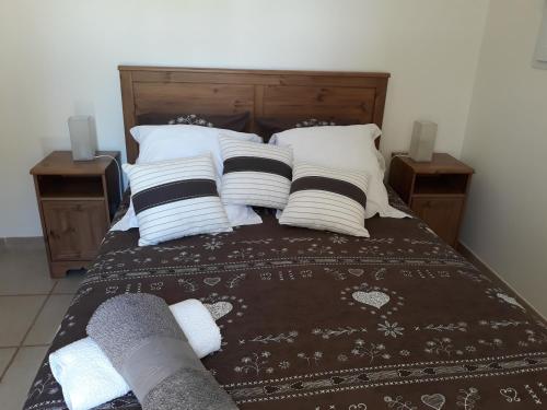 1 cama con varias almohadas y 2 mesitas de noche en Parfums de Provence "Le Lavandin" Piscine chauffée & Spa, en Vaison-la-Romaine