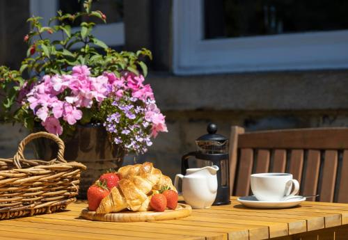 a table with a breakfast of croissants and strawberries on it at Wynnstay House in Harrogate