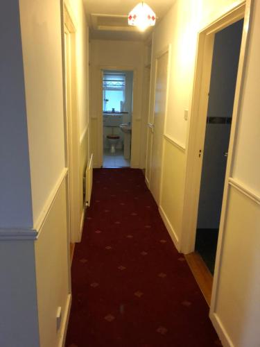 a hallway with a toilet and a red carpet at Drumcoura Bungalow in Leitrim