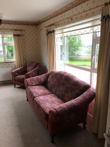 a living room with a couch and a window at Drumcoura Bungalow in Leitrim