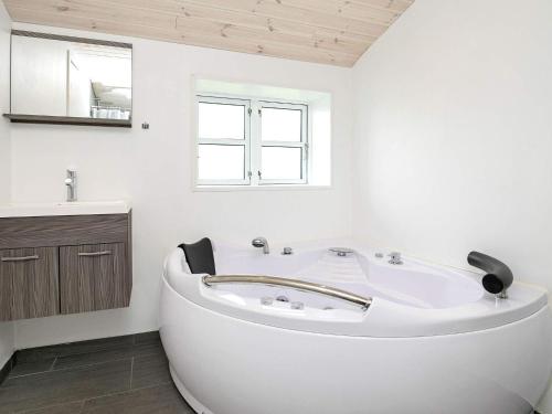 ein weißes Badezimmer mit einer Badewanne und einem Waschbecken in der Unterkunft Holiday home Vestervig XXI in Vestervig