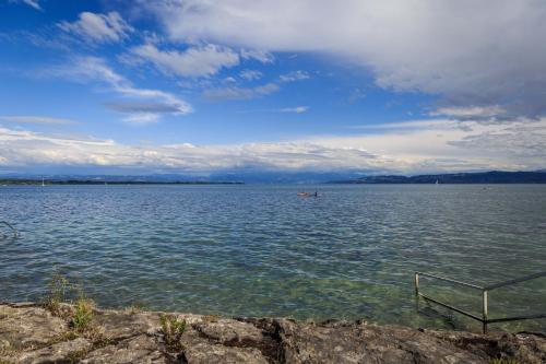 a large body of water with a boat in it at Auszeit Apartment LAKESIDE mit Privatstrand in Friedrichshafen