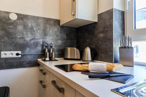 a kitchen with a counter top with a counter sidx sidx sidx at Auszeit Apartment LAKESIDE mit Privatstrand in Friedrichshafen