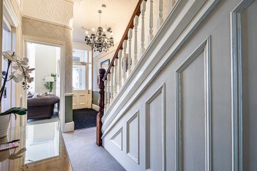 a hallway of a home with stairs and a chandelier at Fountains Guest House - Harrogate Stays in Harrogate