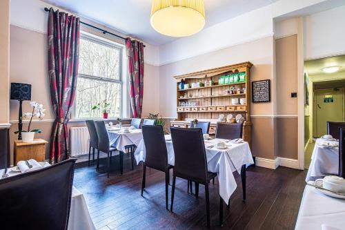 a restaurant with tables and chairs and a window at Fountains Guest House - Harrogate Stays in Harrogate