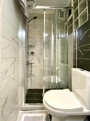 a bathroom with a toilet and a glass shower at La Petite Maison Nicole in Thessaloniki