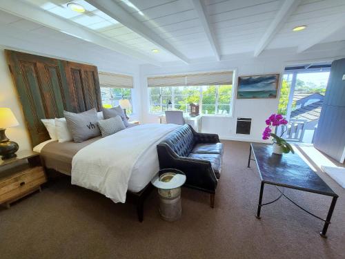 a bedroom with a large bed and a couch at The Vagabond's House Boutique Inn in Carmel