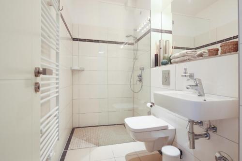 a white bathroom with a sink and a toilet at 5 Personen Altbau nahe Kurfürstendamm - Shakespeare in Berlin