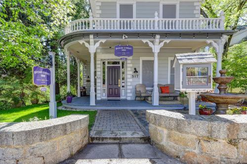 a white house with a porch and a fountain at Broad Street Inn in Nevada City