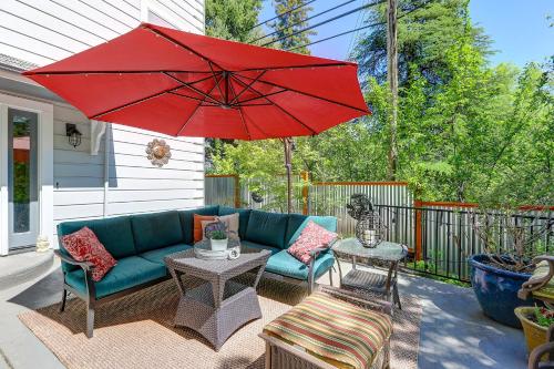 a patio with a blue couch and a red umbrella at Broad Street Inn in Nevada City