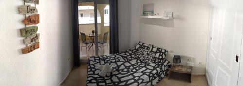 um quarto com uma cama preta e branca num quarto em Bonita y moderna habitación a 300m de la playa em Benalmádena