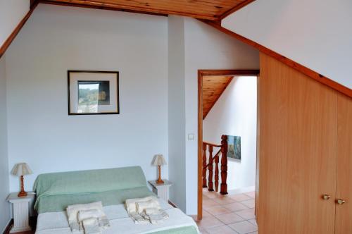 ein Schlafzimmer mit einem Bett in einem Zimmer mit einer Treppe in der Unterkunft Santiago Residence Guest House in Santiago do Cacém