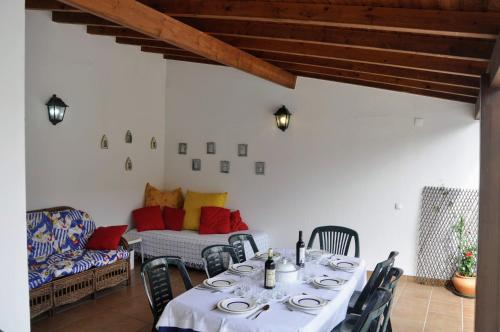 a dining room with a table and chairs and a couch at Santiago Residence Guest House in Santiago do Cacém