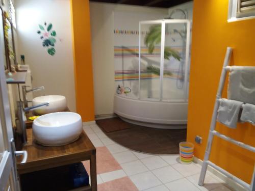 een badkamer met een bad en een toilet. bij Chambre d'hôte La Villa Gialla in Schœlcher