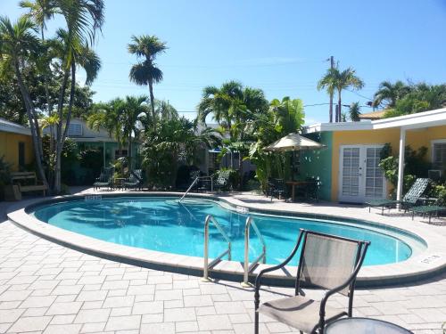 uma piscina com duas cadeiras e uma casa em Alexander Palms Court - No Hidden Resort Fees! em Key West