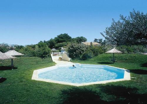 a person in a swimming pool in a yard at Lou Garbin in Saint-Laurent-dʼAigouze