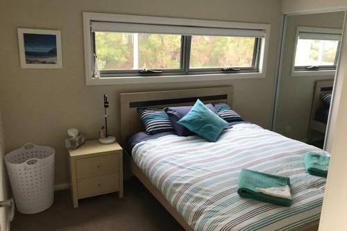 En eller flere senge i et værelse på Amazing Ansons Bay Absolute Waterfront Beach House