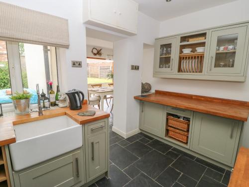 a kitchen with green cabinets and a sink at Griff Lodge in York