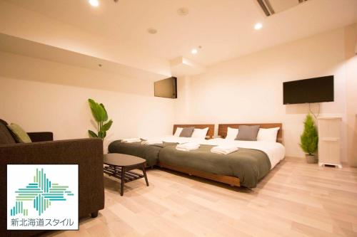 een slaapkamer met een bed en een flatscreen-tv bij SEVEN Building / Vacation STAY 4950 in Asahikawa