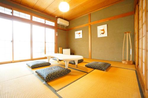 sala de estar con mesa y algunas almohadas en Momiji Takayama en Takayama