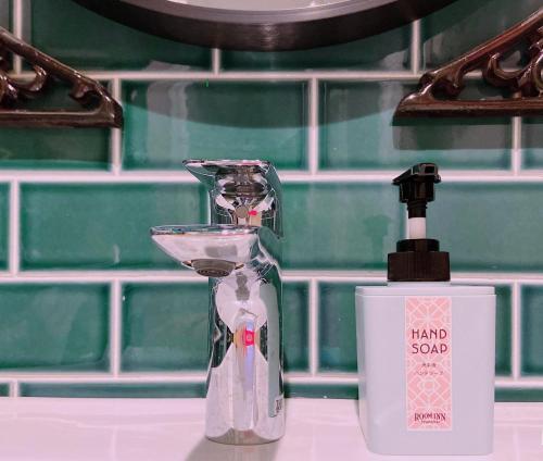 un dispensador de jabón de manos sentado en un mostrador junto a una botella en Room Inn Shanghai 横浜中華街 Room1-ABC, en Yokohama