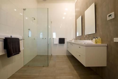 a bathroom with a glass shower and a sink at Villa Talia Tasmania in Wattle Grove