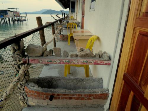 a porch of a house with a table and chairs at Pangkor Fish House in Pangkor