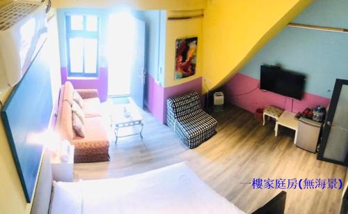 sala de estar con sofá y TV en Sea Forest Homestay, en Suao