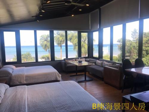 Habitación con 2 camas, sofá y vistas al océano en Sea Forest Homestay, en Suao